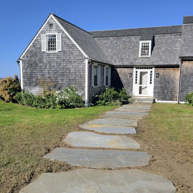 Application image for Full Color Mix Bluestone - Natural Cleft. The image shows this material being used in a path pavers application. The surface finish shown is natural cleft. Dominant colors shown are blue and gray. The color mix creates a warm feeling. Random color pattern.