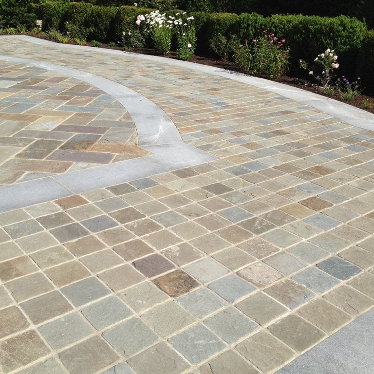 The image shows this material being used in a patio pavers application.