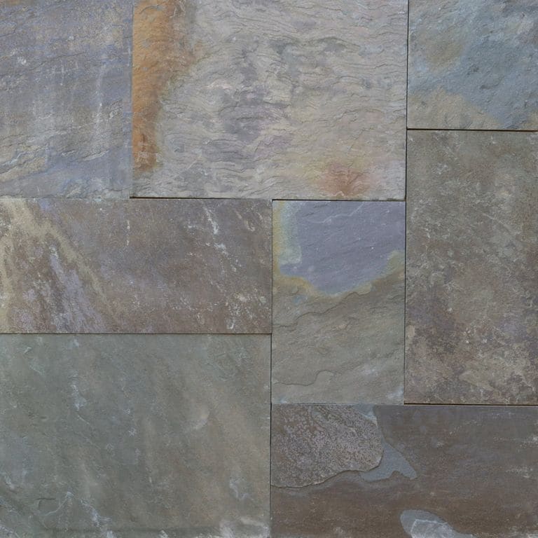 Best close-up image for Bluestone Natural Cleft - Gunmetal. The image shows this material being used in a patio pavers application. The surface finish shown is natural cleft. Dominant colors shown are brown, green and gray; with blue, orange/rust and purple secondaries. Exhibits "movement" and the color mix creates a cool feeling. Regular, blotched and random color patterns.