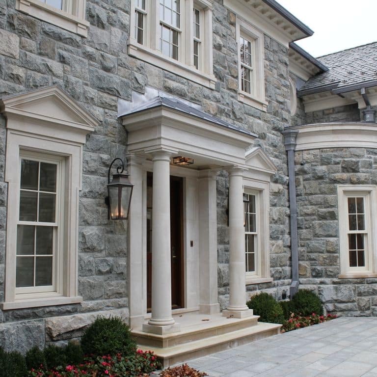 Feature image for Hudson Granite. The image shows this material being used for full bed veneer and thin veneer. The dominant color shown is gray; with beige, blue, brown, green, purple and white secondaries. The color mix creates a cool feeling. Speckled, blotched and cloudy color patterns.
