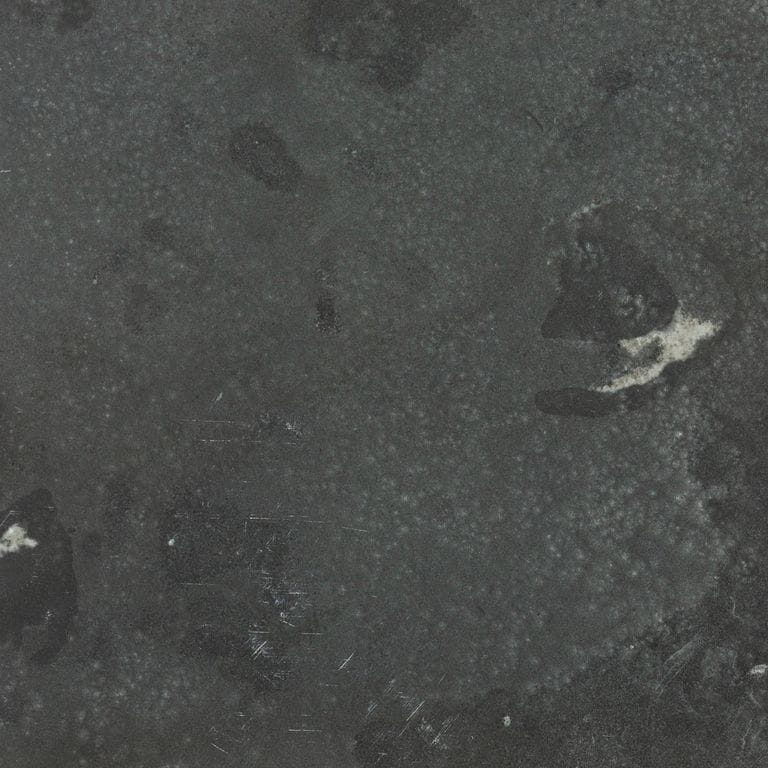 Color/Finish variation image for Limestone - Highland. The surface finish shown is leathered. Dominant colors shown are black and gray; with a black secondary. Exhibits "movement" and the color mix creates a cool feeling. Random color pattern.