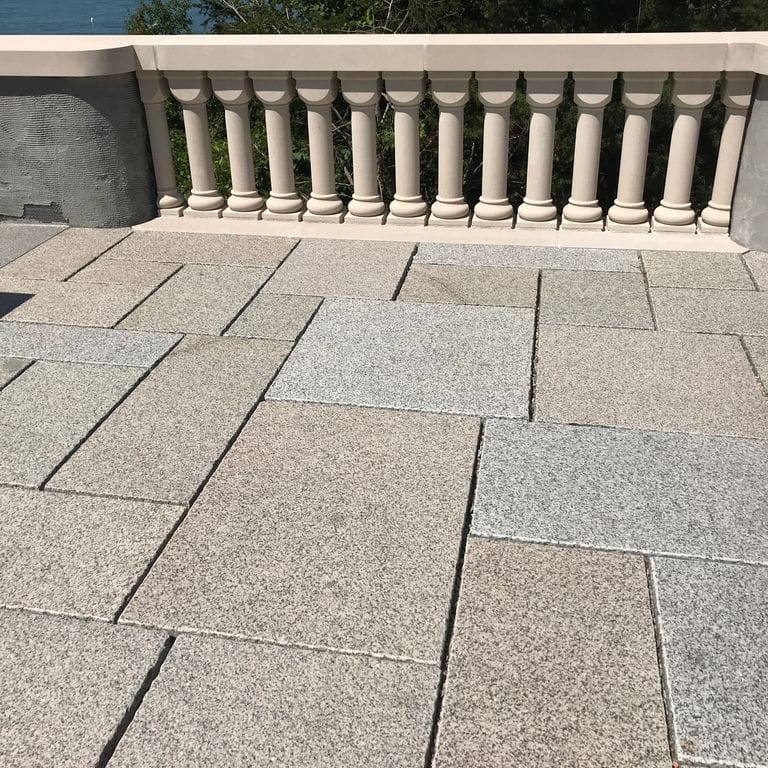 The image shows this material being used in a patio pavers application. Speckled and fine speckled color patterns.
