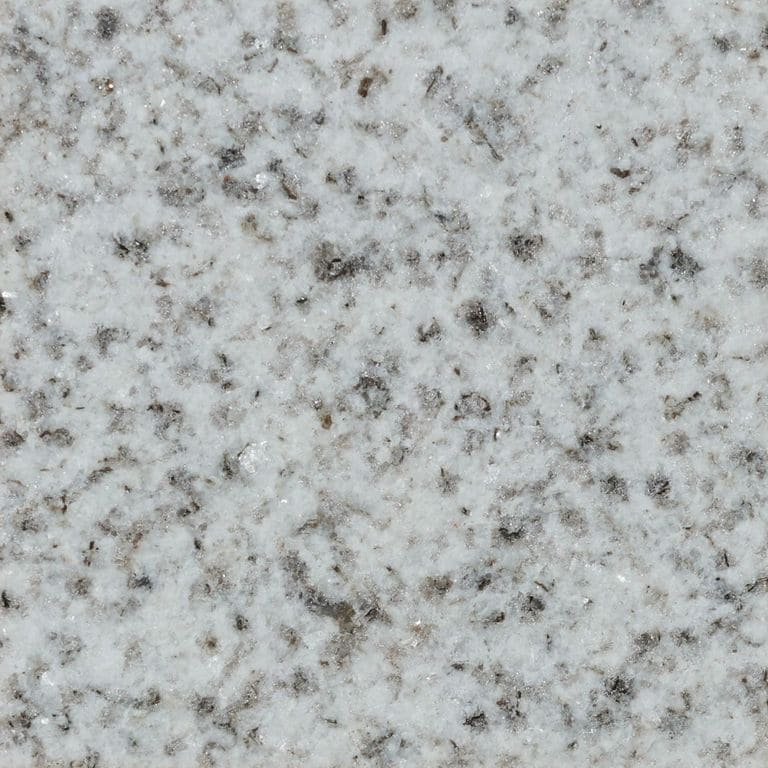Feature image for Bethel White Granite. The surface finish shown is flamed. Dominant colors shown are gray and white; with beige and pink secondaries. The color mix creates a cool feeling. Coarse speckled color pattern.