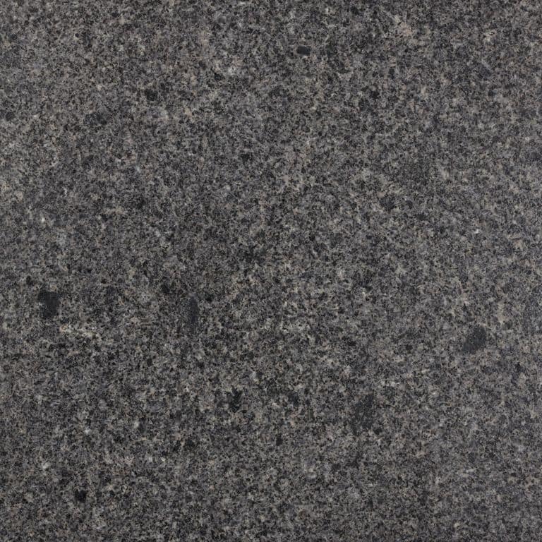 Feature image for Granite - Charcoal Black. The surface finish shown is polished. The dominant color shown is gray; with green and purple secondaries. The color mix creates a cool feeling. Speckled color pattern.