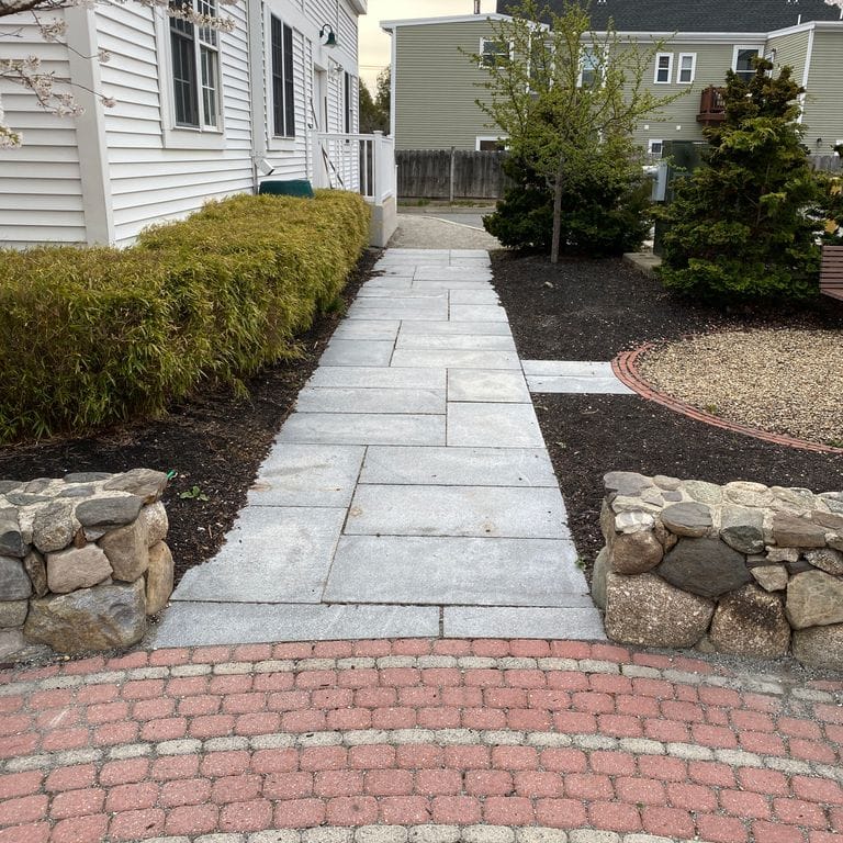 Application image for Granite - Chelmsford Gray. The image shows this material being used in a path pavers application. Dominant colors shown are gray and white. The color mix creates a cool feeling.