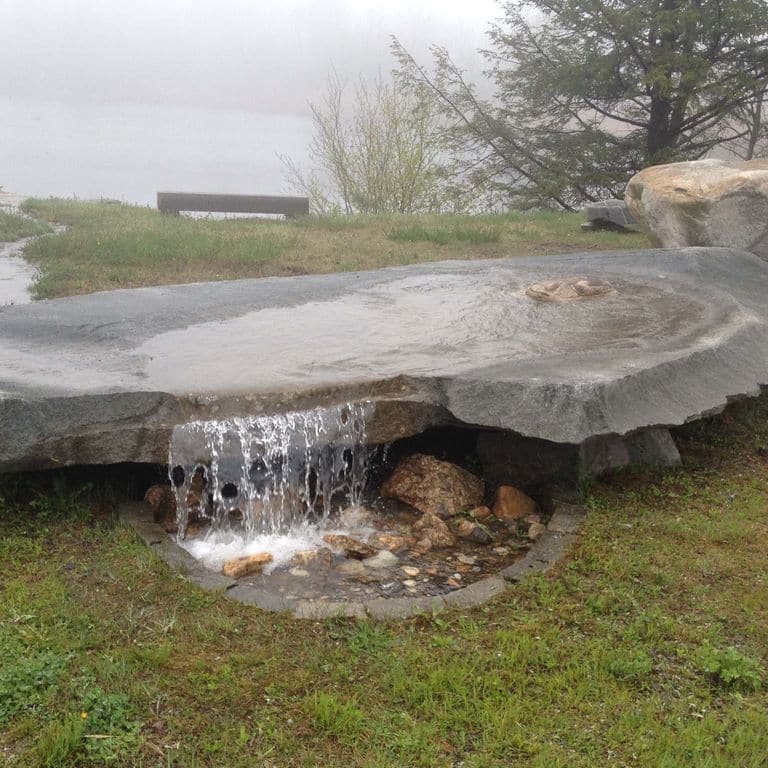 Feature image for Chester Gray Granite. The image shows this material being used in a fountains application. The dominant color shown is gray; with a white secondary. The color mix creates a cool feeling. Fine speckled and cloudy color patterns. Contains some mica and mineral inclusions.