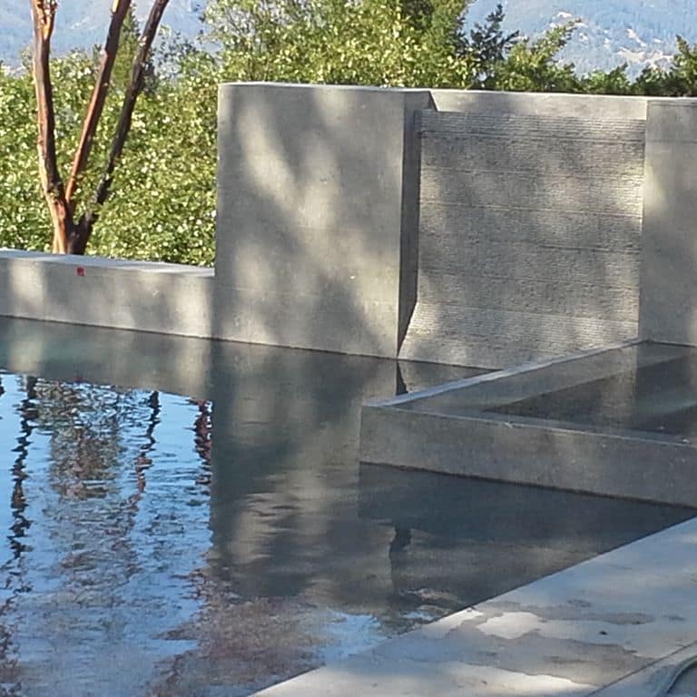 Application image for Dawn Haze Limestone. The image shows this material being used for pool coping, thin veneer and pool deck pavers. The surface finish shown is honed. Dominant colors shown are brown and gray; with a purple secondary. The color mix creates a cool feeling. Solid color pattern.