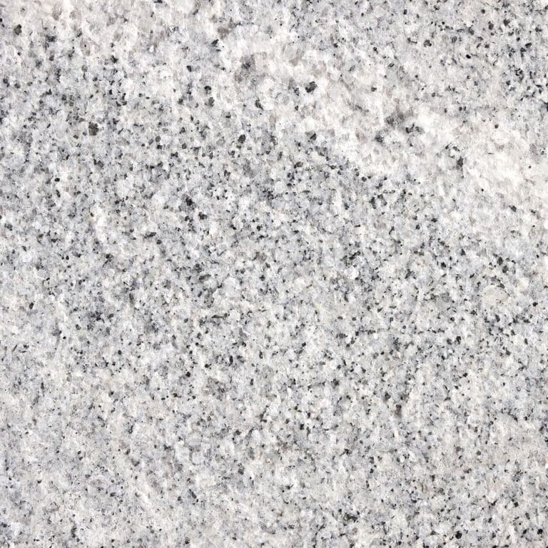 Color/Finish variation image for Granite - Kitledge. The surface finish shown is flamed. Dominant colors shown are gray and white; with beige, pink and cream secondaries. Exhibits "movement" and the color mix creates a cool feeling. Speckled color pattern.