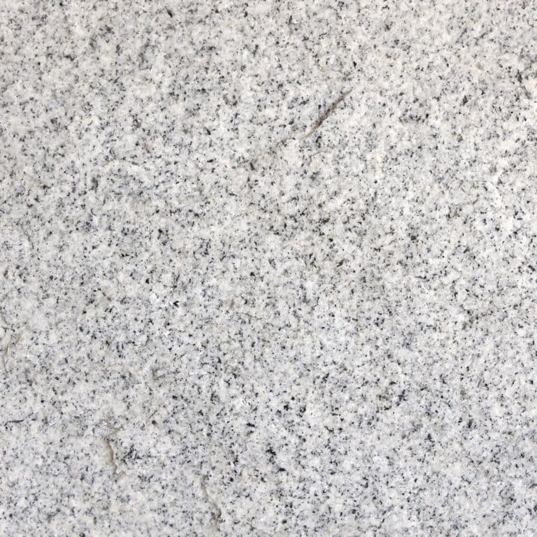 Color/Finish variation image for Kitledge Gray Granite. The surface finish shown is split-face. The dominant color shown is gray; with beige, pink, white and cream secondaries. The color mix creates a cool feeling. Speckled color pattern.