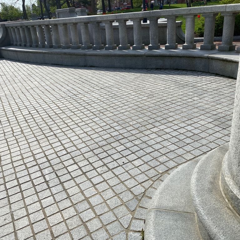 Application image for Kitledge Gray Granite. The image shows this material being used for architectural elements, landscape curbing &amp; edging, patio pavers and monolithic steps. The dominant color shown is gray. The color mix creates a cool feeling. Speckled color pattern.