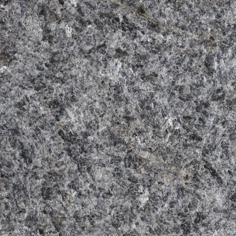 Best close-up image for Mesabi Black® Granite. The surface finish shown is flamed. The dominant color shown is gray; with black, blue, brown, green, purple and white secondaries. The color mix creates a cool feeling. Speckled, blotched and coarse speckled color patterns. Contains some mica and mineral inclusions.