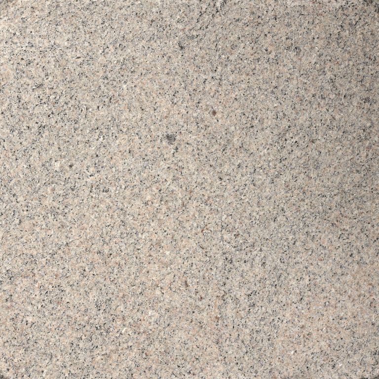 Close-up image for Moonlit Rose Granite. The surface finish shown is flamed. Dominant colors shown are beige, gray and tan; with brown, orange/rust, pink, purple, white and cream secondaries. The color mix creates a warm feeling. Fine speckled color pattern. Contains mineral inclusions.