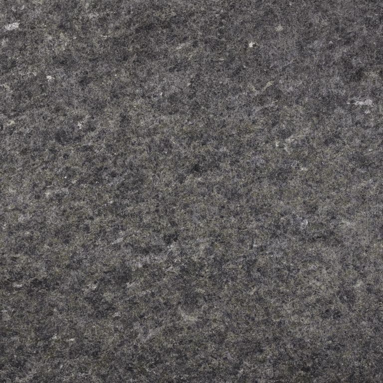 Close-up image for Peribonka Granite. The surface finish shown is flamed. Dominant colors shown are brown and gray; with black, green and purple secondaries. Exhibits "movement" and the color mix creates a cool feeling. Coarse speckled color pattern. Contains some mica and mineral inclusions.