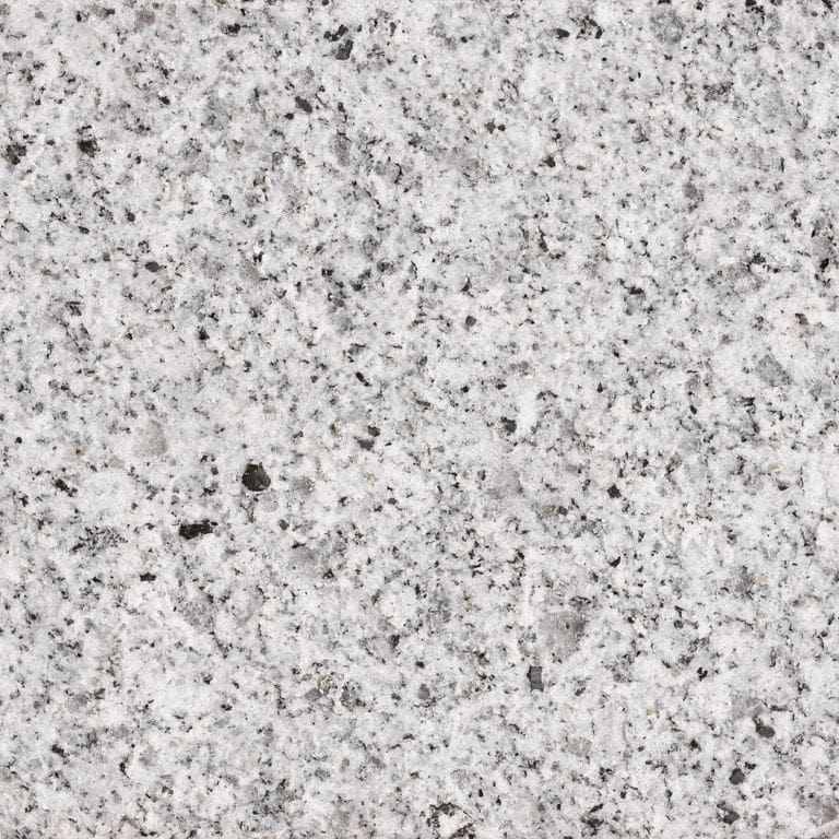 Best close-up image for Sierra White® Granite. The surface finish shown is flamed. Dominant colors shown are gray and white; with beige, pink and cream secondaries. Fine speckled and speckled color patterns. Contains some mica and mineral inclusions.
