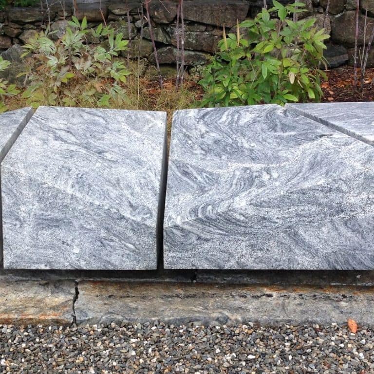Feature image for Silver Cloud Granite. The image shows this material being used in a seating &amp; benches application. The surface finish shown is sawn. Dominant colors shown are gray and white; with pink and cream secondaries. Exhibits "movement" and the color mix creates a cool feeling. Linear, streaked and fine speckled color patterns.