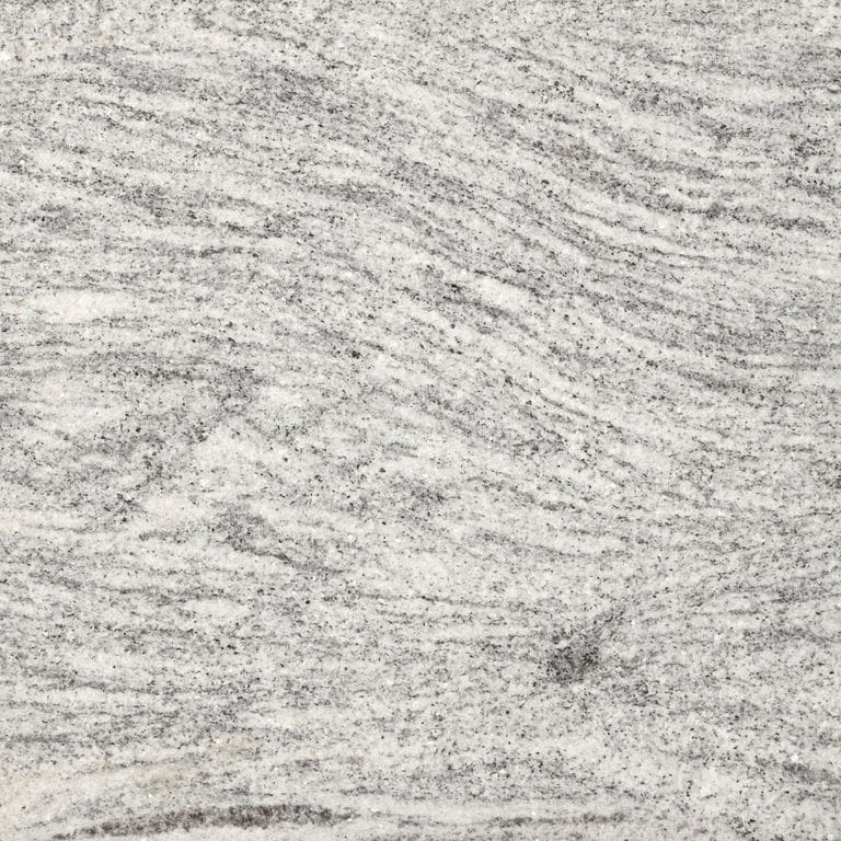 Best close-up image for Silver Cloud Granite. The surface finish shown is flamed. Dominant colors shown are gray and white; with beige and cream secondaries. Exhibits "movement" and the color mix creates a cool feeling. Linear, streaked and fine speckled color patterns.