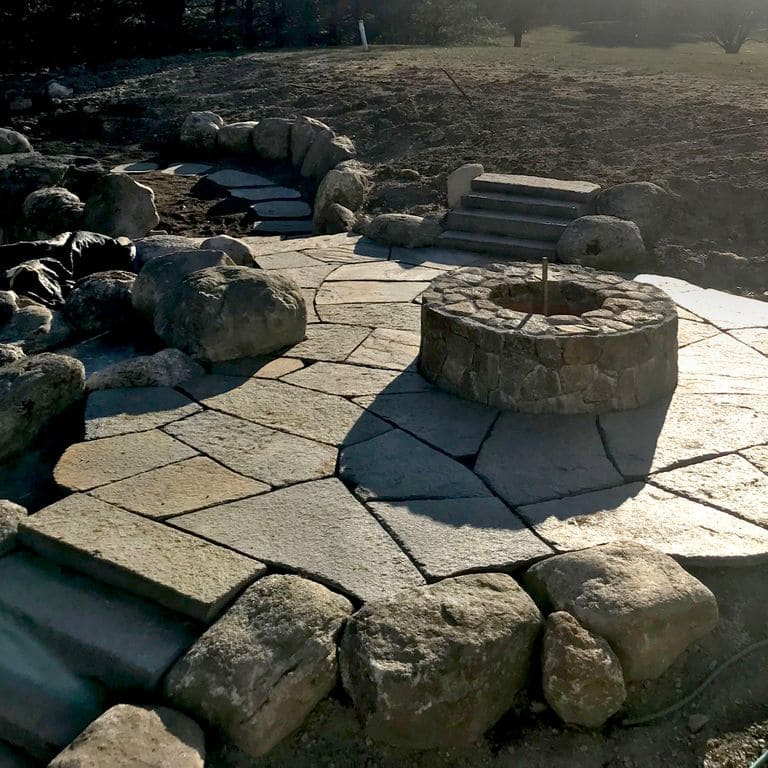 The image shows this material being used for outdoor fire concepts and patio pavers. Blotched color pattern.