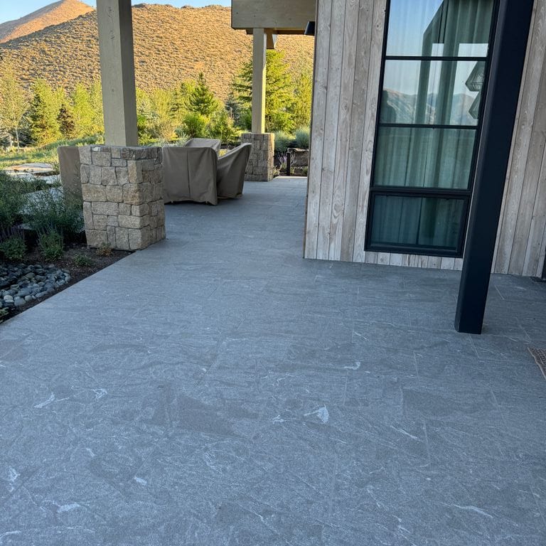 Application image for Granite - Jet Mist. The image shows this material being used in a patio pavers application. The dominant color shown is gray.
