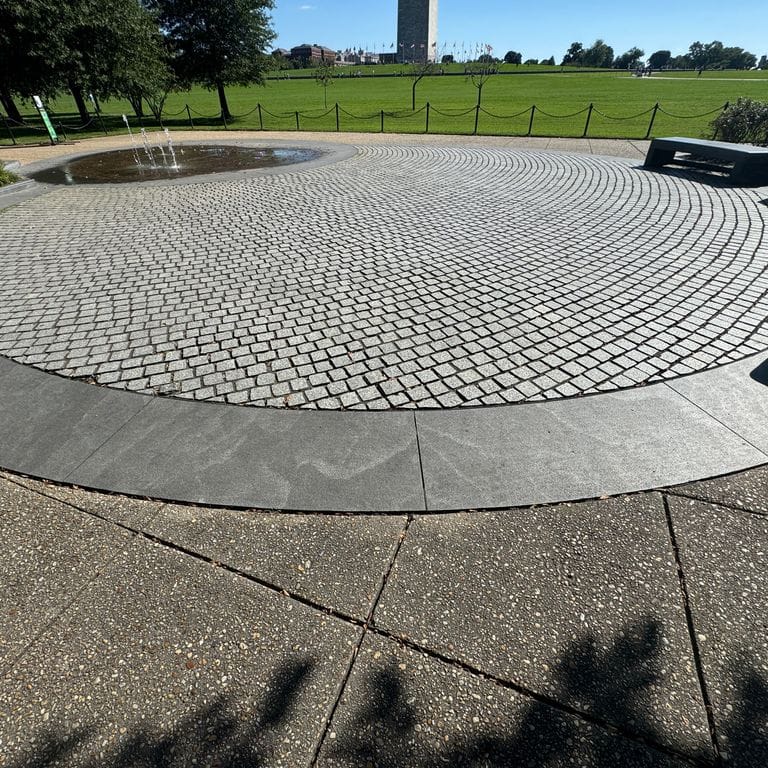 Application image for Granite - Jet Mist. The image shows this material being used in a path pavers application. The dominant color shown is gray. The color mix creates a warm feeling.
