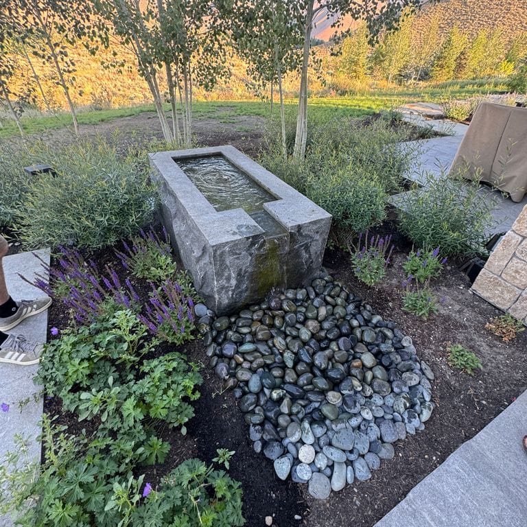 Application image for Granite - Jet Mist. The image shows this material being used for water features, garden accents and sculpture &amp; carvings. The surface finish shown is split-face. The dominant color shown is gray. The color mix creates a warm feeling.