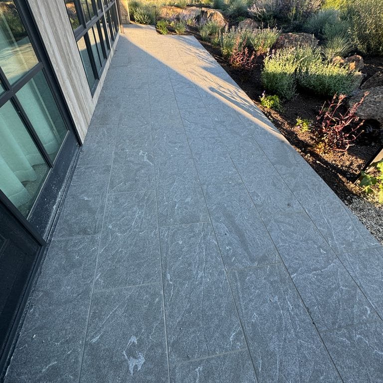 Application image for Granite - Jet Mist. The image shows this material being used in a path pavers application. The dominant color shown is gray. The color mix creates a warm feeling.