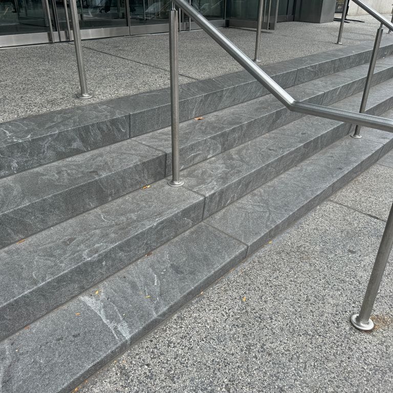 Application image for Granite - Jet Mist. The image shows this material being used in a monolithic steps application. The dominant color shown is gray. The color mix creates a cool feeling.