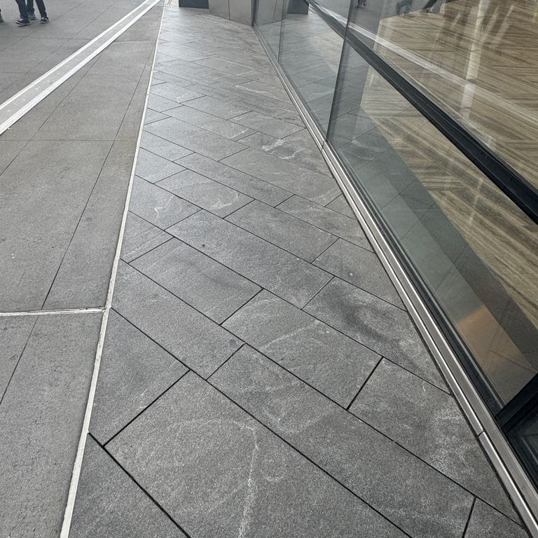 Application image for Granite - Jet Mist. The image shows this material being used in a path pavers application. The dominant color shown is gray. The color mix creates a cool feeling.