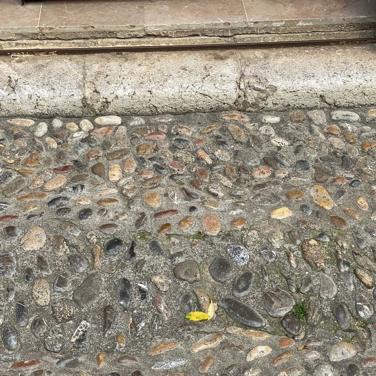 The image shows this material being used in a driveway pavers application.