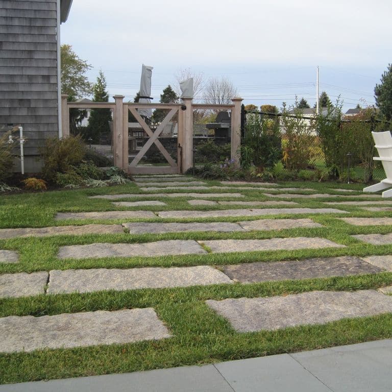 Feature image for Reclaimed Rustic Granite. The image shows this material being used in a patio pavers application. The surface finish shown is . The dominant color shown is gray; with beige, brown, orange/rust, purple, white, tan and cream secondaries. The color mix creates a warm feeling. Speckled and blotched color patterns.