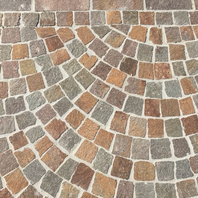Close-up image for Porphyry Natural Surface - Mixed Red. Dominant colors shown are beige, brown, orange/rust and tan; with green, gray, purple and cream secondaries. The color mix creates a warm feeling. Regular, speckled and fine speckled color patterns.