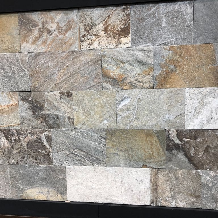 Close-up image for Greek Quartzite Slate - Seam Face. Dominant colors shown are gray, white and tan; with beige, black, brown, green, orange/rust, purple and cream secondaries. Exhibits "movement" and the color mix creates a warm feeling. Random, linear, swirled and streaked color patterns.