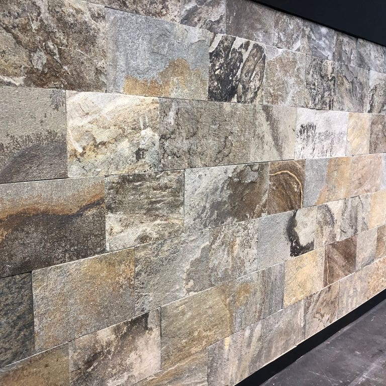 Feature image for Quartzite - Greek Slate - Seam Face. The image shows this material being used for thin veneer and interior cladding. Dominant colors shown are beige, gray and tan; with black, brown, green, orange/rust, pink, purple, white and cream secondaries. Exhibits "movement" and the color mix creates a warm feeling. Streaked, swirled, blotched and random color patterns.