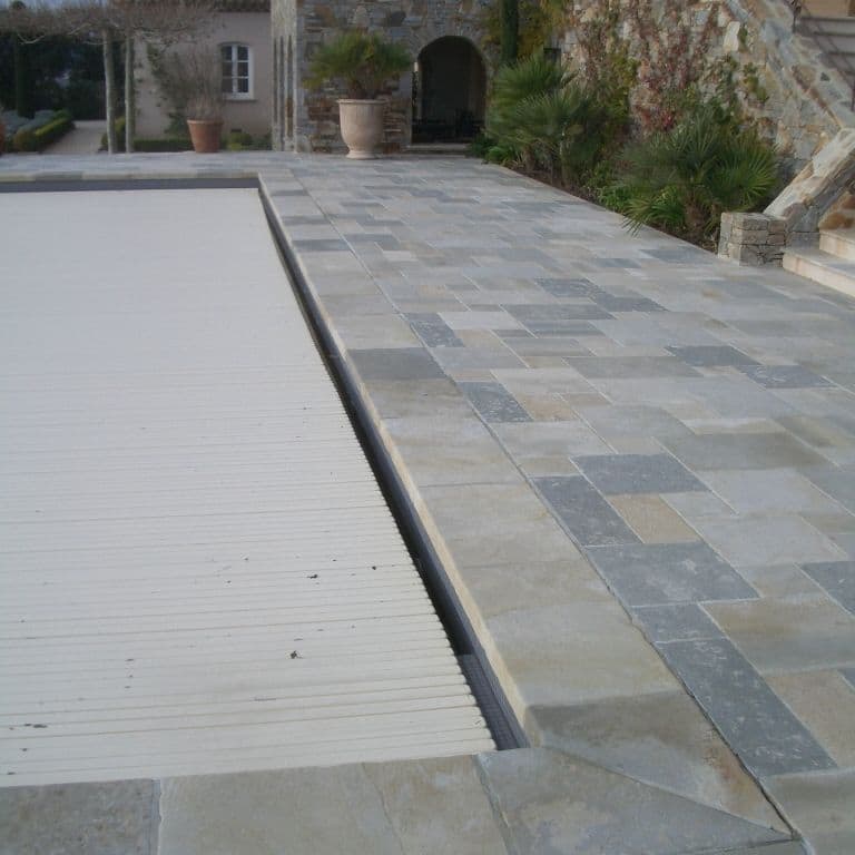 Application image for Mixed Limestone Blend. The image shows this material being used for pool coping and pool deck pavers. The dominant color shown is gray. The color mix creates a cool feeling.
