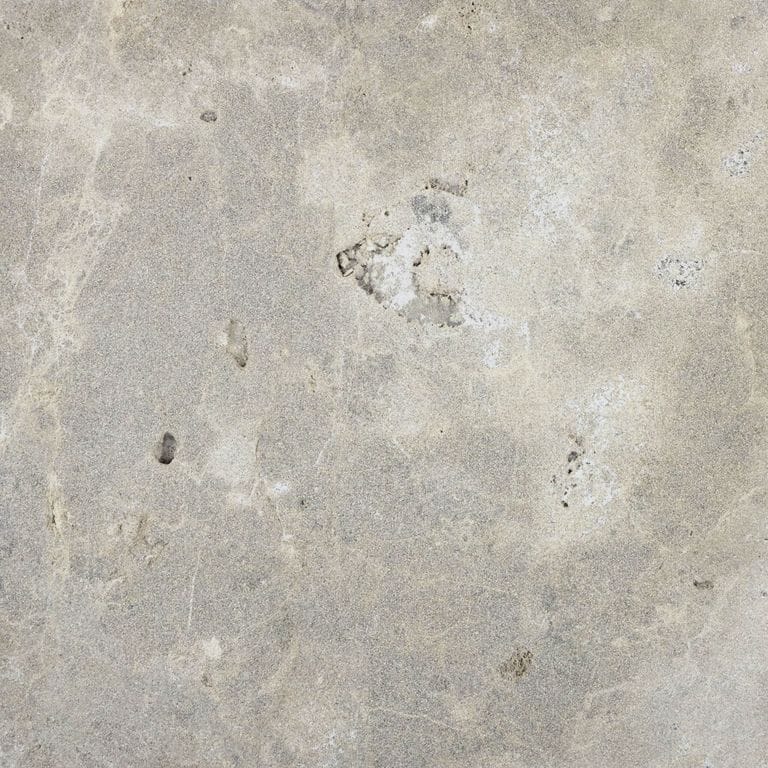 Color/Finish variation image for Bavarian Dolomite - Gray. The surface finish shown is sand blasted. Dominant colors shown are beige and gray; with blue, pink, purple, white, tan and cream secondaries. Exhibits "movement". Random and cloudy color patterns. Contains voids and mineral inclusions.