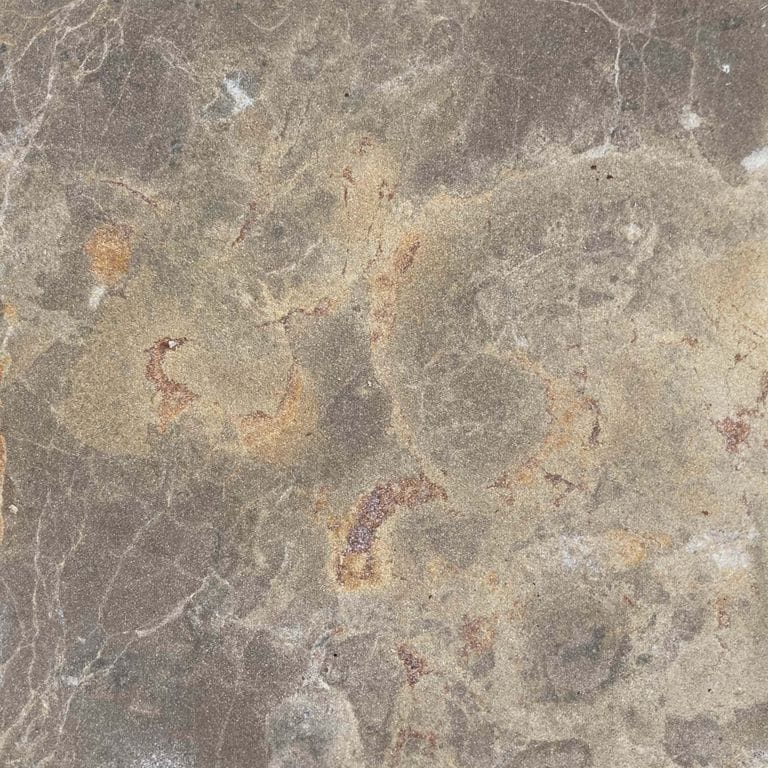 Color/Finish variation image for Bavarian Dolomite - Gray. The surface finish shown is sand blasted. Dominant colors shown are gray and tan; with beige, brown, orange/rust and purple secondaries. Exhibits "movement" and the color mix creates a warm feeling. Blotched and random color patterns. Contains voids.