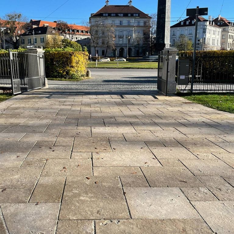 Application image for Bavarian Dolomite - Gray. The image shows this material being used for driveway pavers and patio pavers. The surface finish shown is flamed. Dominant colors shown are gray and tan; with black, brown and orange/rust secondaries. The color mix creates a warm feeling.