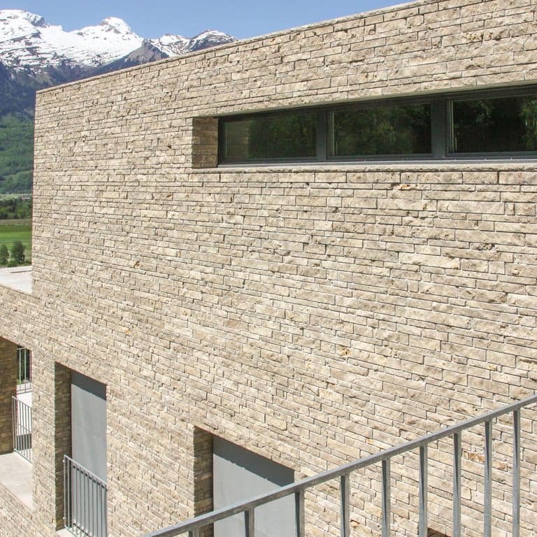 Application image for Bavarian Dolomite - Gray. The image shows this material being used for full bed veneer and thin veneer. The surface finish shown is split-face. Dominant colors shown are beige and tan. The color mix creates a warm feeling. Cloudy color pattern.