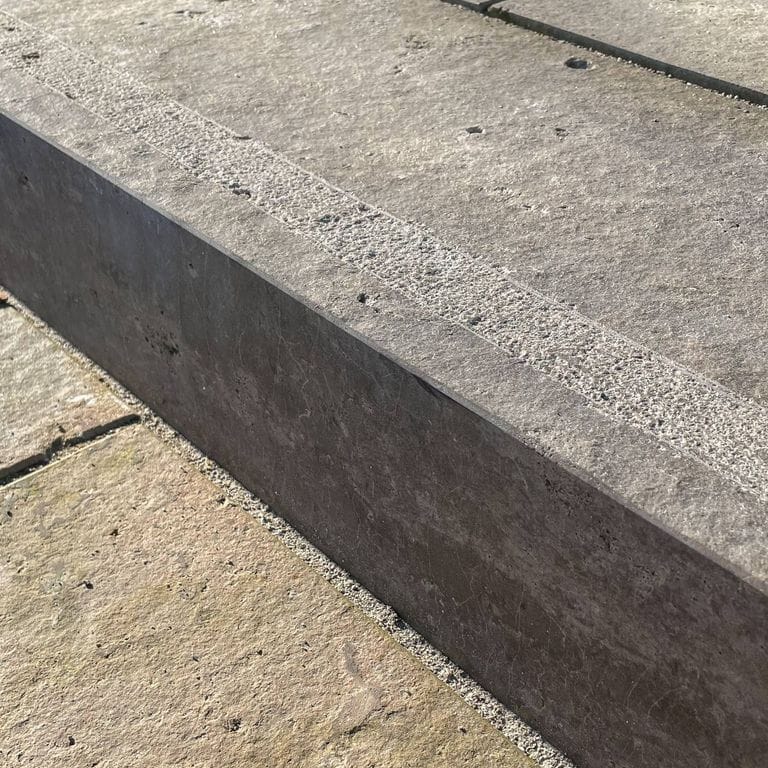 Application image for Bavarian Dolomite - Gray. The image shows this material being used for landscape curbing &amp; edging, driveway pavers and patio pavers. The surface finish shown is flamed. Dominant colors shown are gray and tan. The color mix creates a warm feeling. Regular and cloudy color patterns.