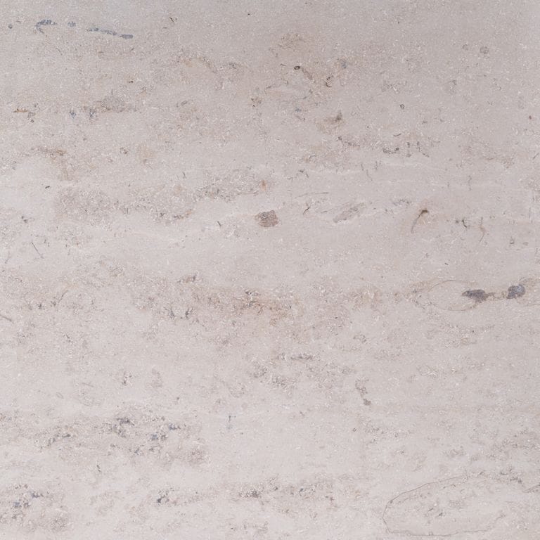 Color/Finish variation image for Bavarian Travertine - Beige. The surface finishes shown are brushed and sand blasted. Dominant colors shown are beige and gray; with pink, purple, white and cream secondaries. Exhibits "movement". Cloudy color pattern.