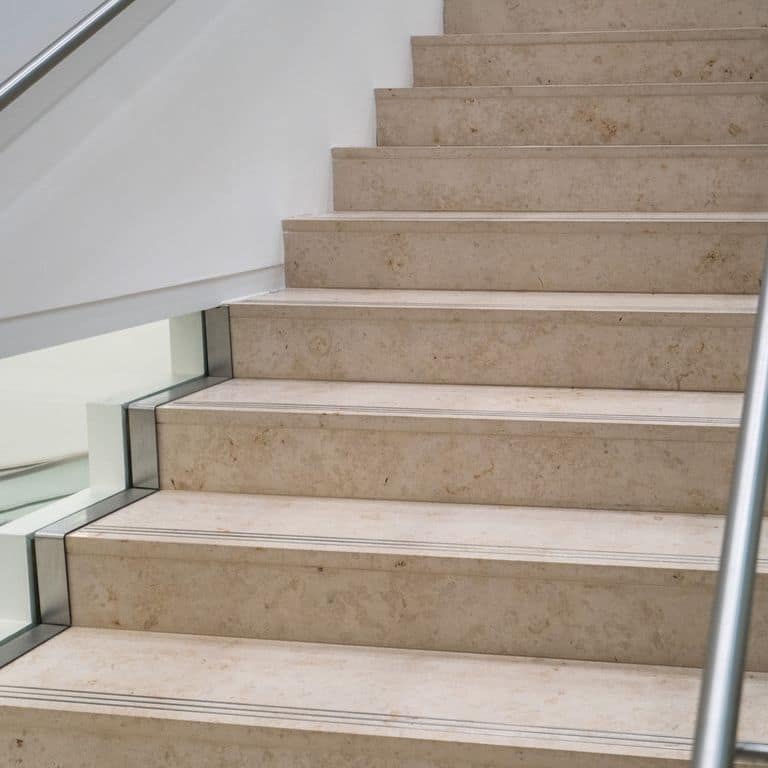 Application image for Bavarian Travertine - Beige. The image shows this material being used for landings and treads. This is a building and landscape stone for outdoor commercial and residential applications. Moderate to higher on the price spectrum.