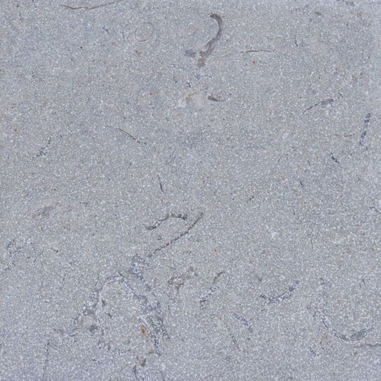 Color/Finish variation image for Blue Harbor Limestone. The surface finishes shown are brushed and sand blasted. Dominant colors shown are blue and gray; with a white secondary. Exhibits "movement" and the color mix creates a cool feeling. Fine speckled and cloudy color patterns.