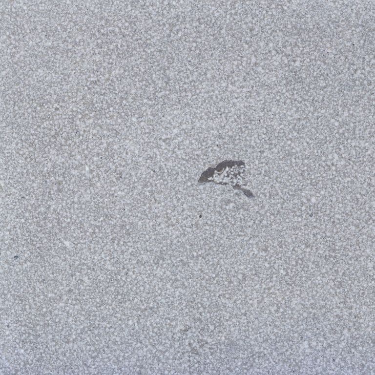 Color/Finish variation image for Blue Peak Limestone. The surface finishes shown are brushed and sand blasted. The dominant color shown is gray; with a white secondary. The color mix creates a cool feeling. Random and speckled color patterns.