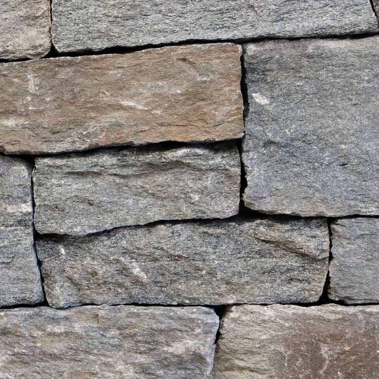 Feature image for Old Chester Granite. The image shows this material being used in a thin veneer application. The surface finish shown is . Dominant colors shown are gray and tan. Regular and linear color patterns.