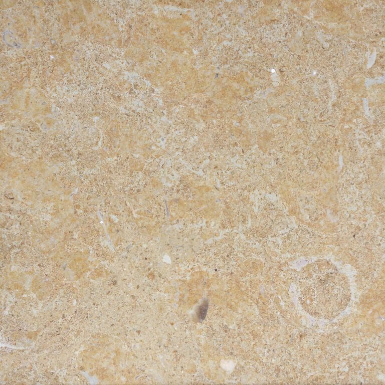 Swatch image for Limestone - Caravaggio. The surface finish shown is a combination of honed and polished. Dominant colors shown are beige, orange/rust and tan; with brown, gray and cream secondaries. Exhibits "movement" and the color mix creates a warm feeling. Random, cloudy and coarse speckled color patterns. Contains mineral inclusions.