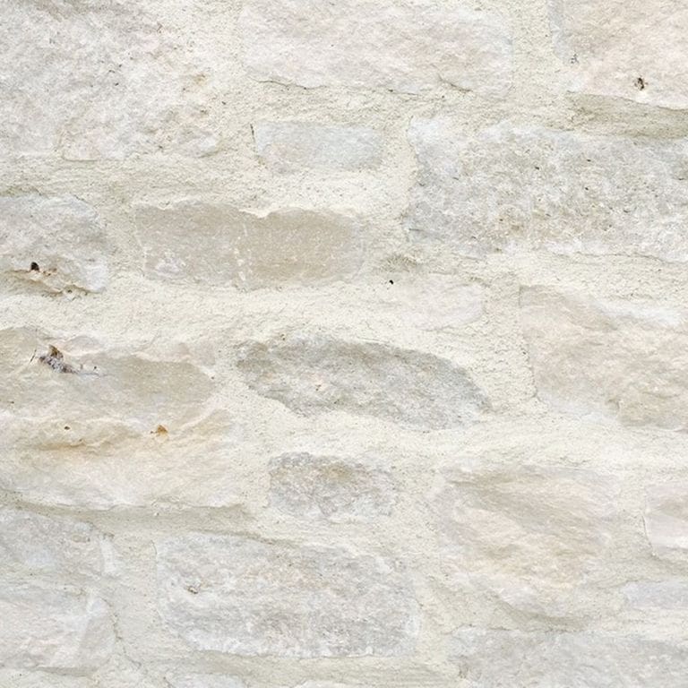 Best close-up image for Tundra Cream Limestone. The image shows this material being used for full bed veneer and thin veneer. The surface finish shown is split-face. Dominant colors shown are beige, gray, white and cream; with pink and tan secondaries. The color mix creates a warm feeling. Regular color pattern.
