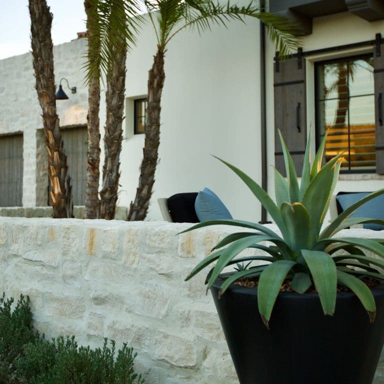 Application image for Tundra Cream Limestone. The image shows this material being used for full bed veneer and thin veneer. The surface finish shown is split-face. The dominant color shown is gray; with beige and white secondaries. The color mix creates a warm feeling. Regular color pattern.