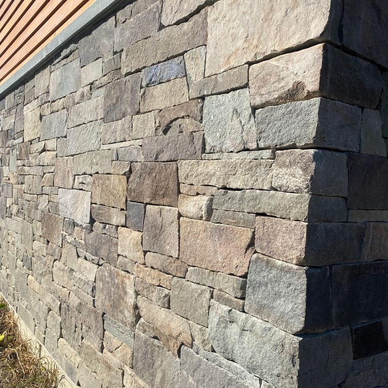 Best close-up image for Fieldstone - Pennsylvania. The image shows this material being used for full bed veneer and thin veneer. The surface finish shown is split-face. Dominant colors shown are brown, gray and tan; with green, orange/rust, purple and tan secondaries. Exhibits "movement". Regular, blotched and random color patterns.