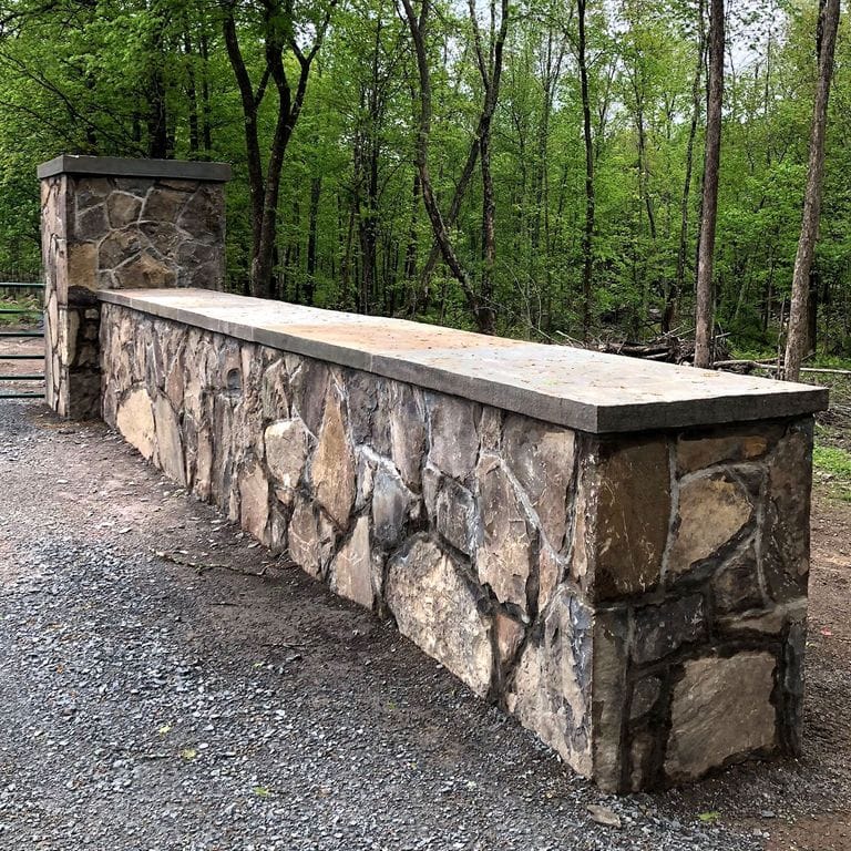 The image shows this material being used in a landscape wallstone application.