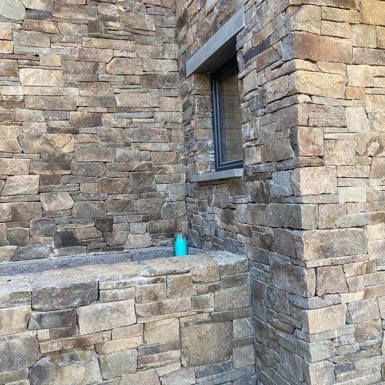 Application image for Fieldstone - Pennsylvania. The image shows this material being used in a thin veneer application. The surface finish shown is split-face. Dominant colors shown are gray and tan.