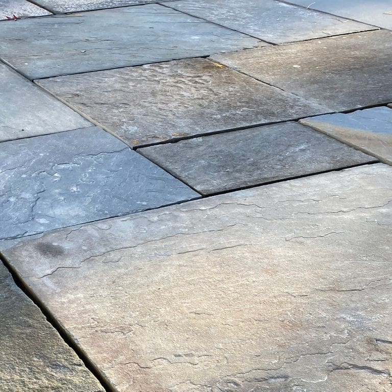 Close-up image for Reclaimed Bluestone. The surface finish shown is natural cleft. Dominant colors shown are blue, brown and gray; with beige, white, tan and cream secondaries. Exhibits "movement" and the color mix creates a cool feeling. Random color pattern.